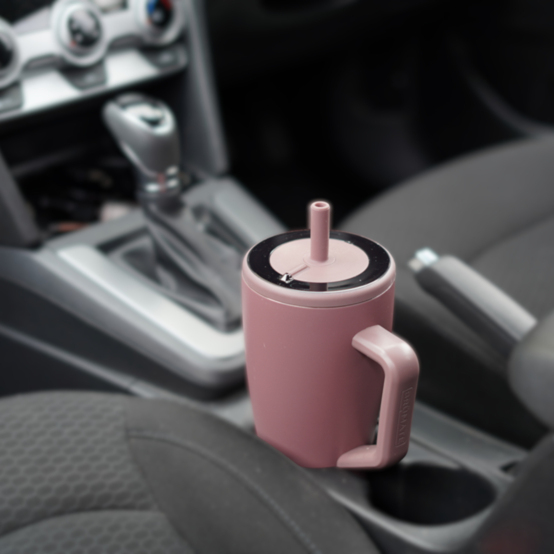 Brumate reusable water bottle containing Access Filter Straw in cup holder in car