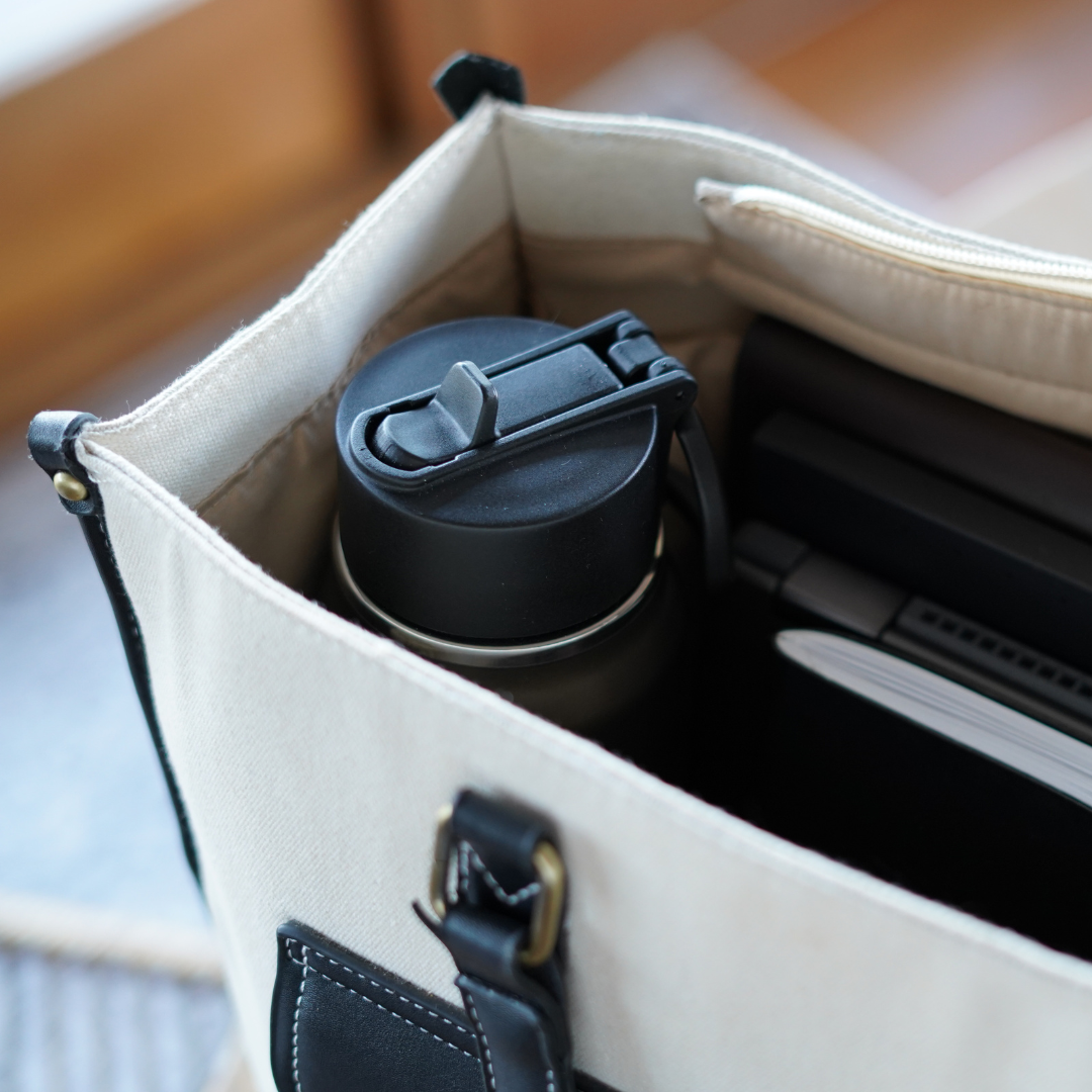 Hydro Flask reusable water bottle containing Access Filter Straw in canvas tote with laptop and notebook